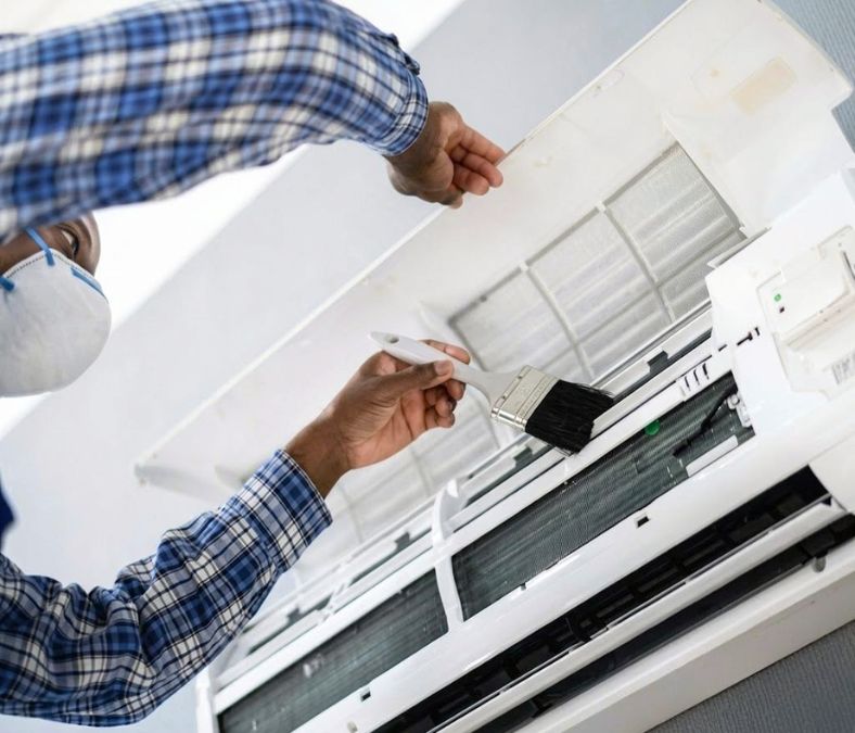 HVAC technician performing AC system maintenance