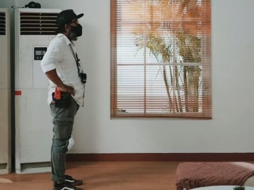 Homeowner checking signs that an air conditioner needs servicing