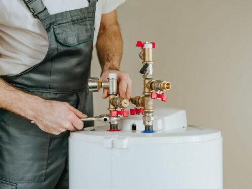 Plumber inspecting connections after water heater installation in Kansas City.